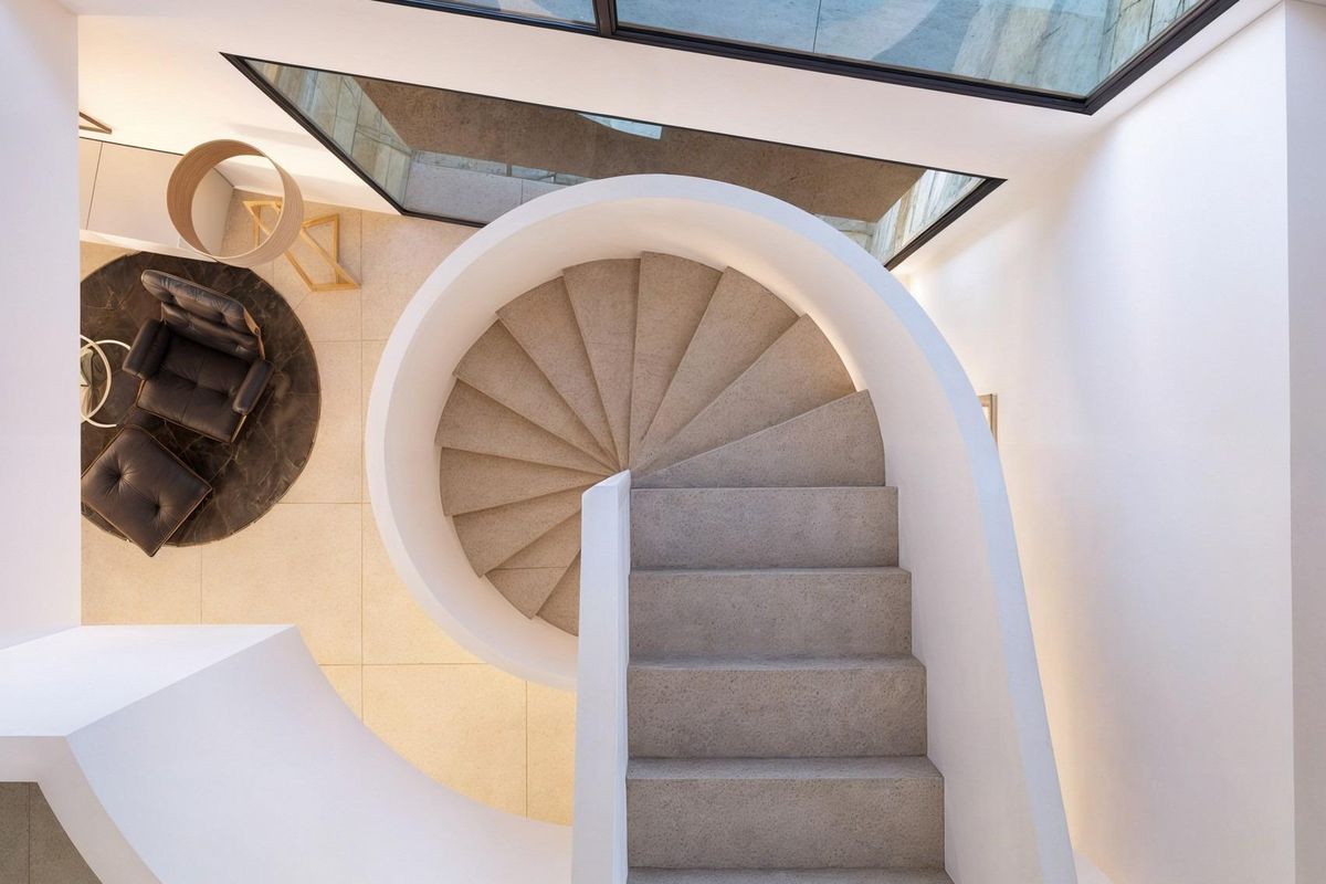 Uitzicht op de spiraaltrap van boven in de villa in Moraira, met elegante designelementen.