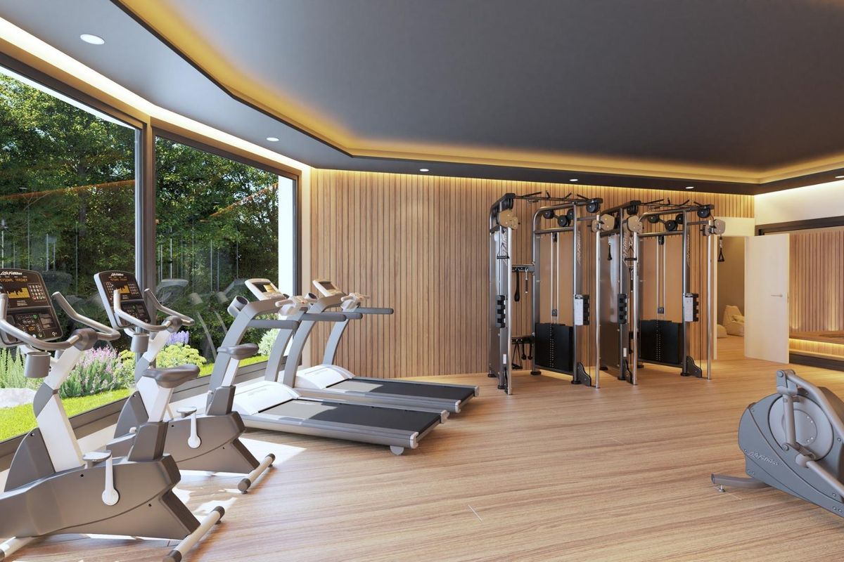 Lichte fitnessruimte met tuinzicht in herenhuis in Mijas, loopbanden en gewichten voor training.