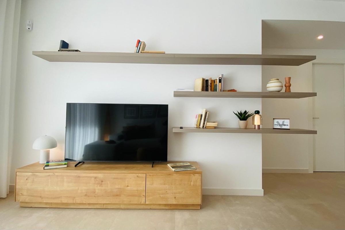 Moderne planken en entertainmentcentrum in een stijlvolle woonkamer van een gelijkvloers appartement in Pilar de La Horadada.