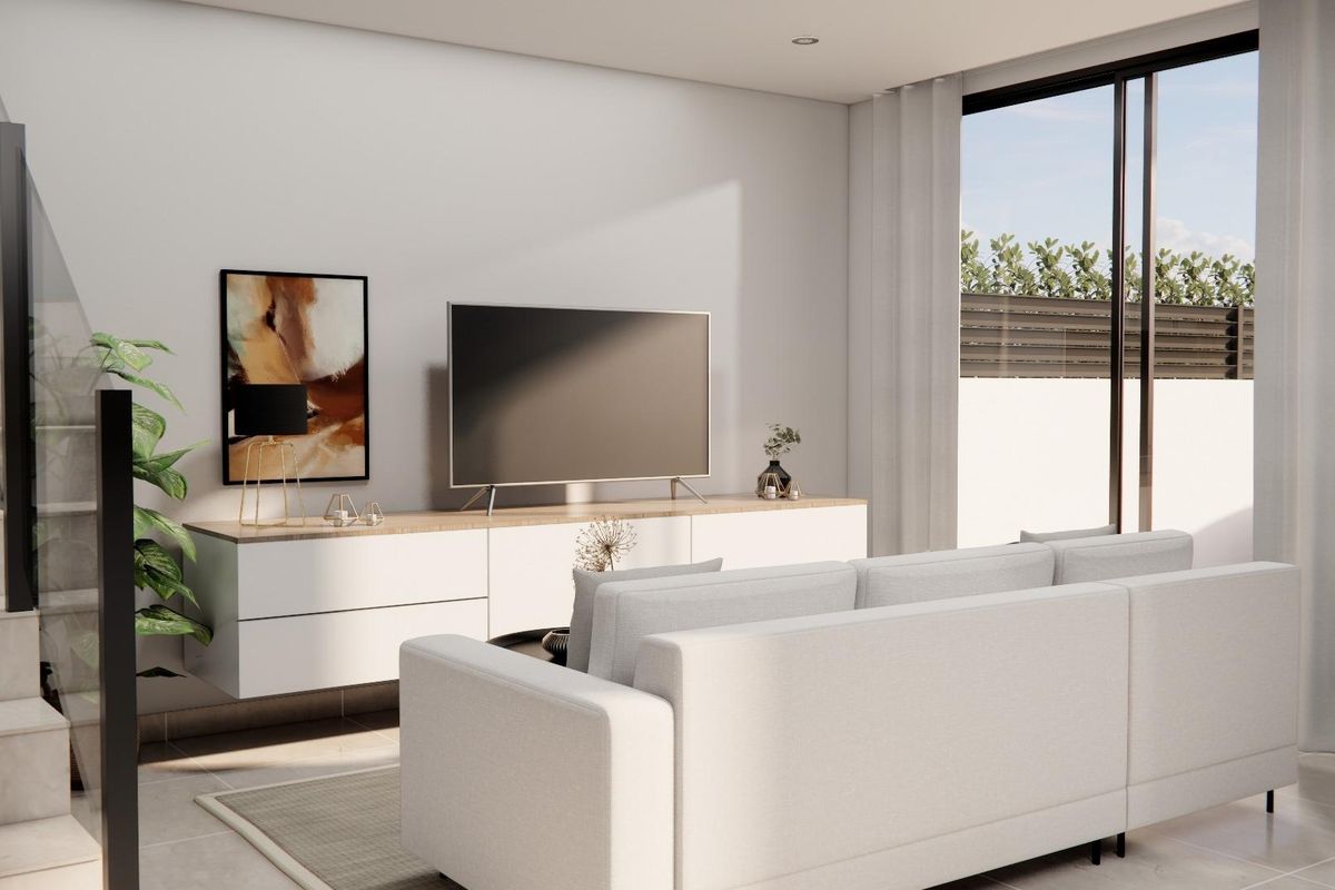 Heldere woonkamer van de townhouse in Rojales, met een grote tv en moderne inrichting, vol natuurlijk licht.
