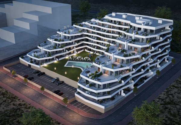 Luchtfoto van een modern appartementencomplex met een zwembad en een aangelegde tuin in San Miguel de Salinas.