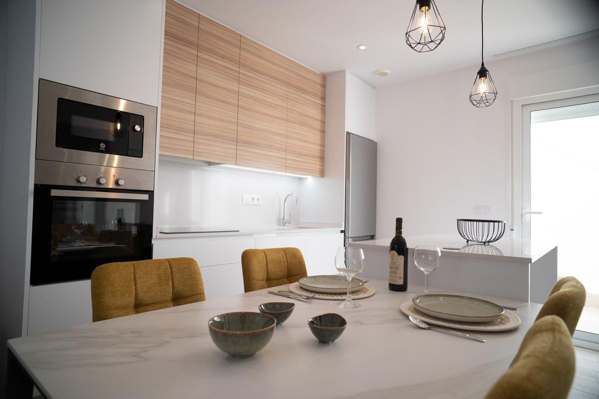 Dining area and kitchen inside a modern townhouse in San Javier. Includes a dining table and kitchen appliances.