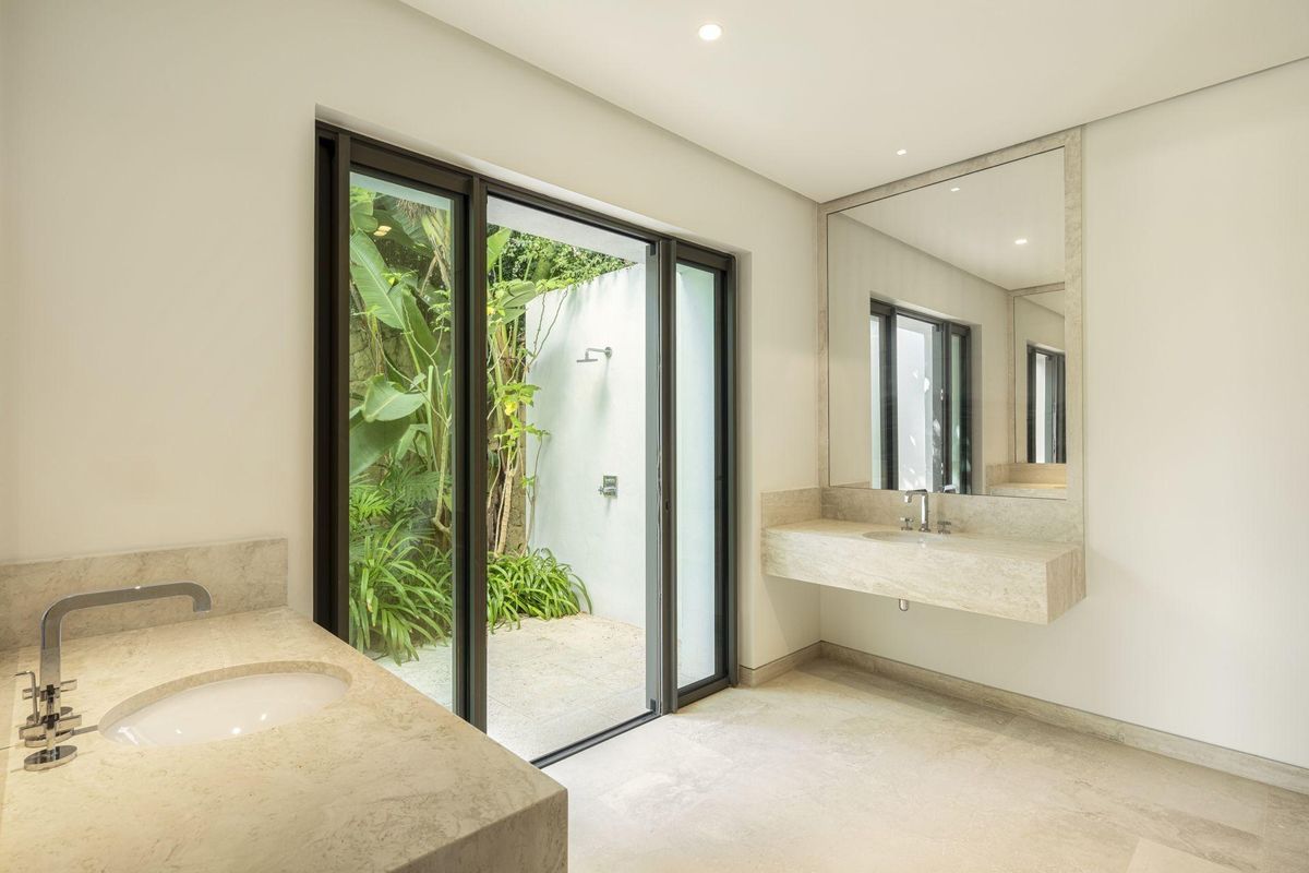 Moderne badkamer met een rustige sfeer en uitzicht op de tuin, te vinden in een luxueuze villa in Casares.