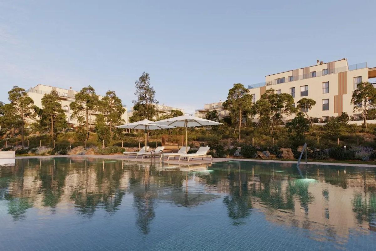 Zijaanzicht van het zwembad met ligstoelen en appartementen in Godella, Costa Blanca Noord, Spanje.