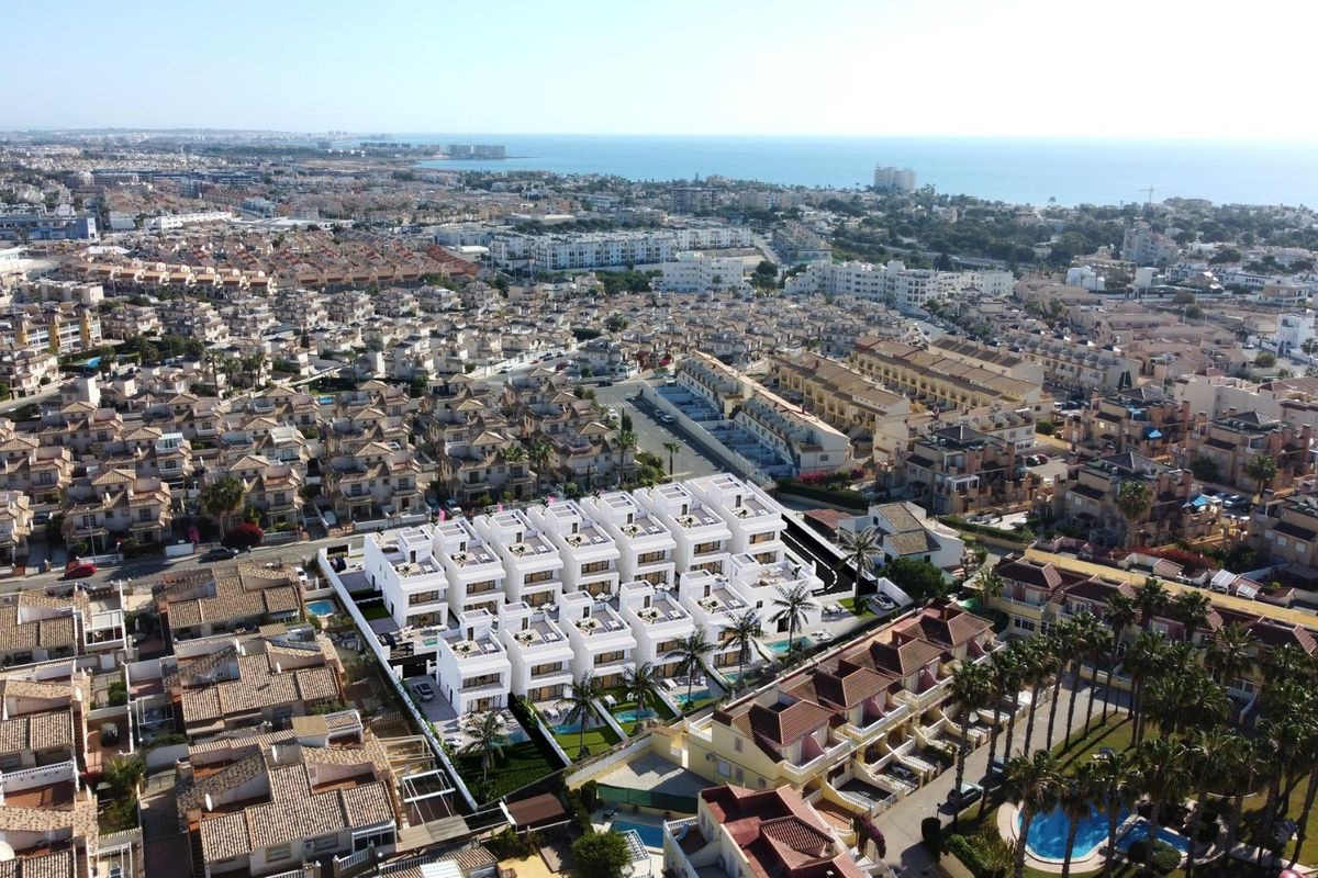 Luchtfoto van een townhousegebied in Orihuela Costa, met focus op de nabijheid van de zee en stedelijke voorzieningen.