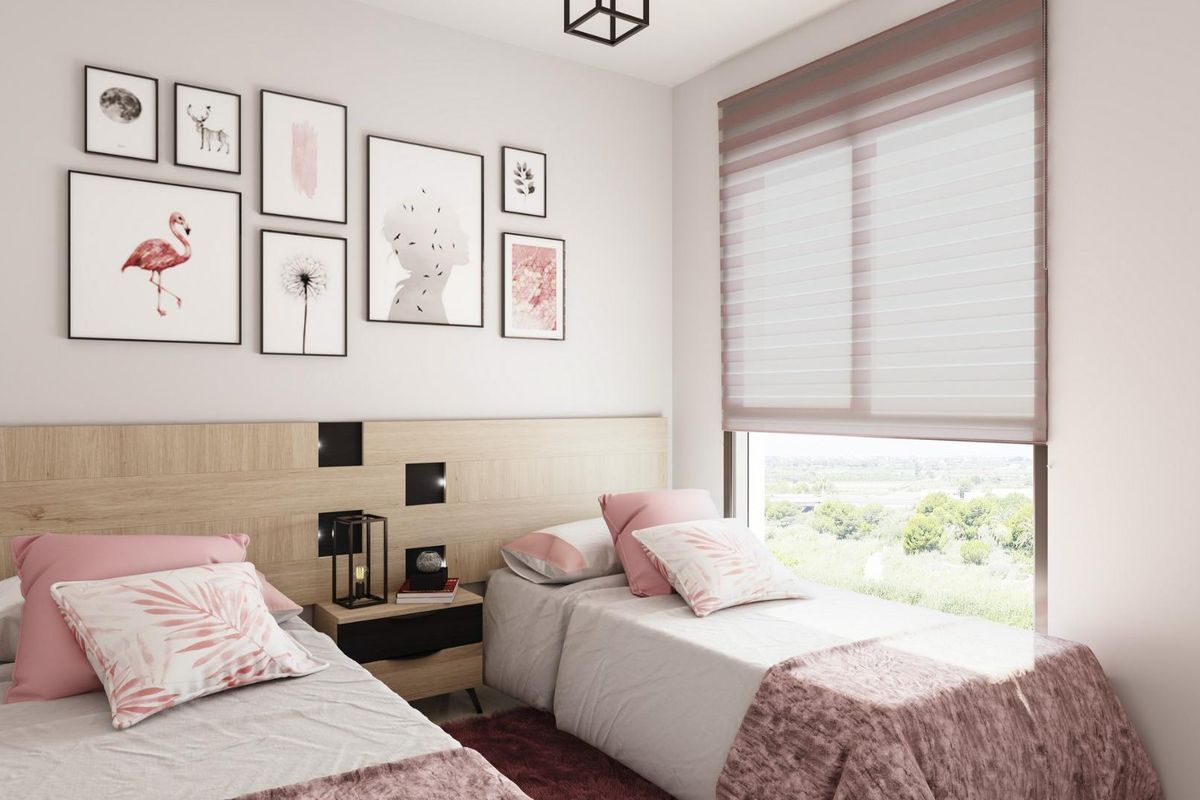 Charmante twin slaapkamer in een penthouse in Guardamar del Segura, versierd met speelse kunst en gezellige beddengoed.