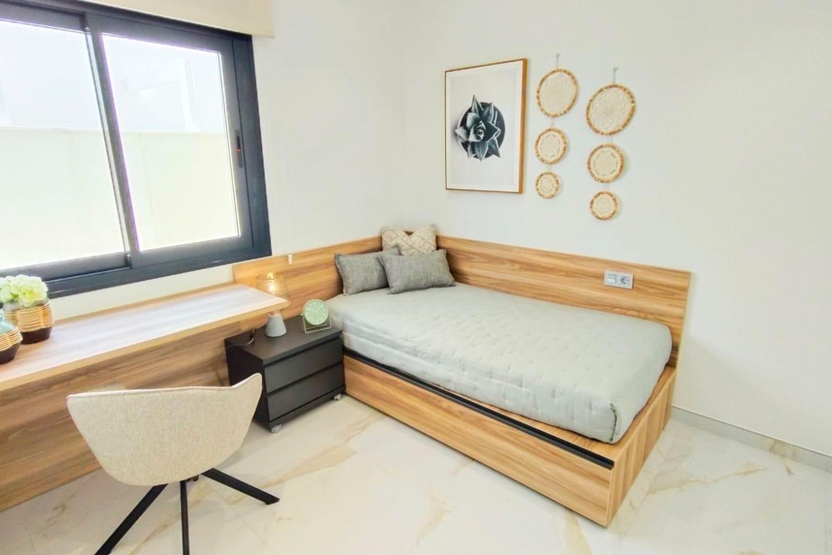 Gezellige slaapkamer met een eenpersoonsbed, bureau en wanddecoratie in een moderne villa in Pilar de La Horadada.