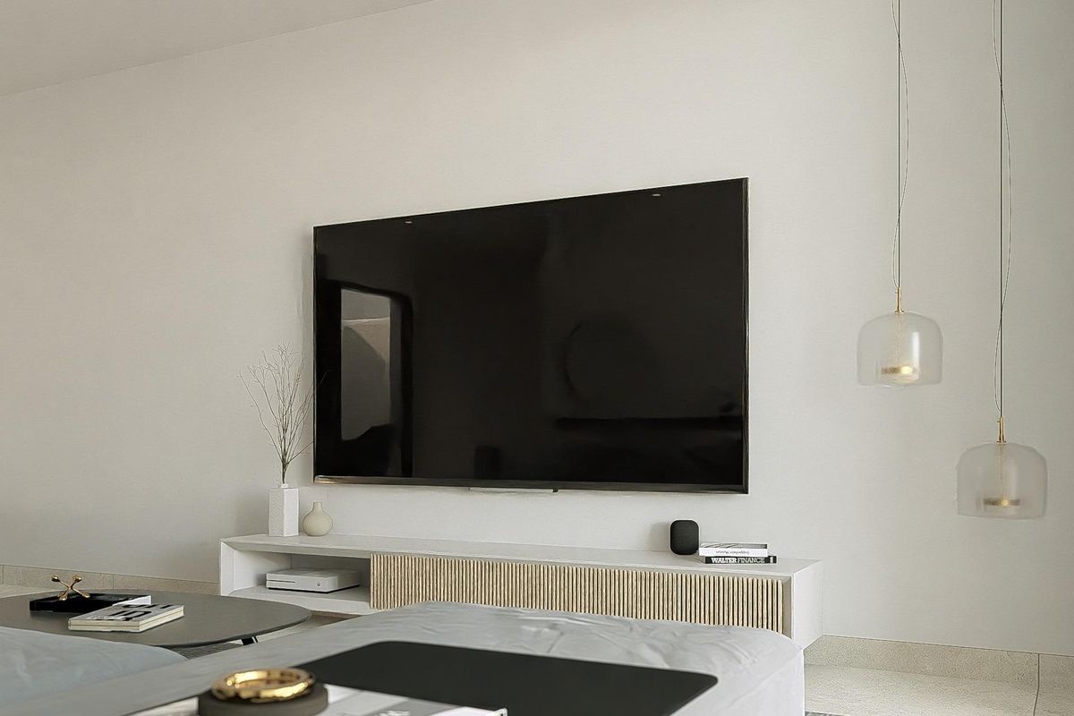 Woonruimte met een grote TV en moderne designelementen in het interieur van de penthouse in Los Alcazares.