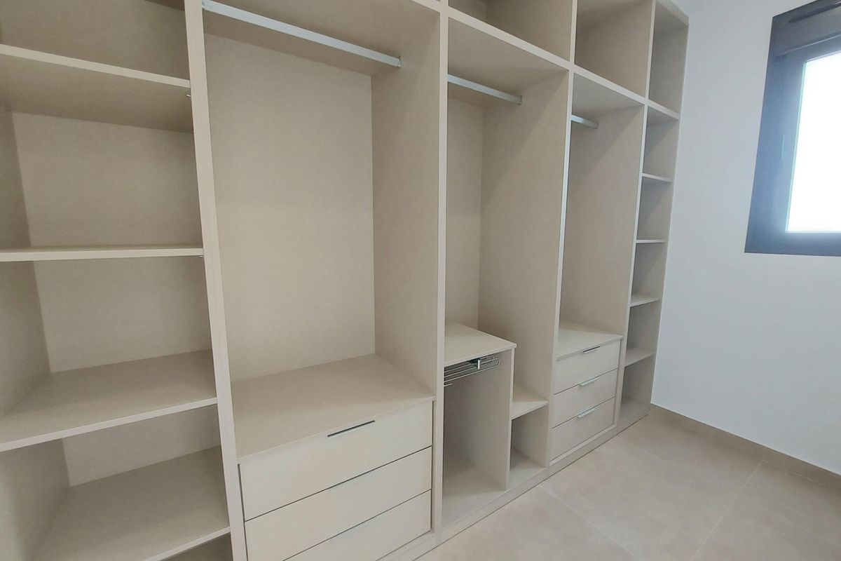 Goed georganiseerde inloopkast die veel opbergruimte biedt in een villa in San Pedro del Pinatar.