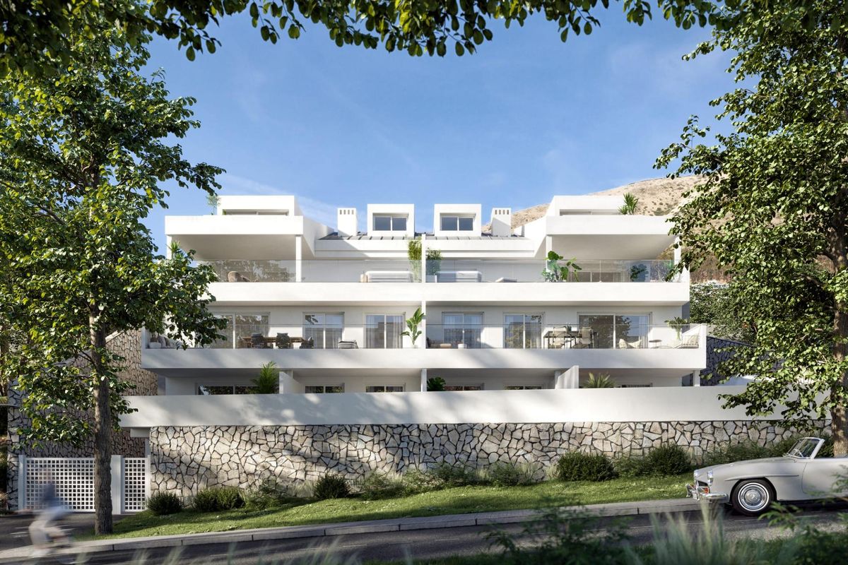 Modern appartementencomplex met witte gevel, omringd door weelderig groen nabij Benalmádena, Costa del Sol.