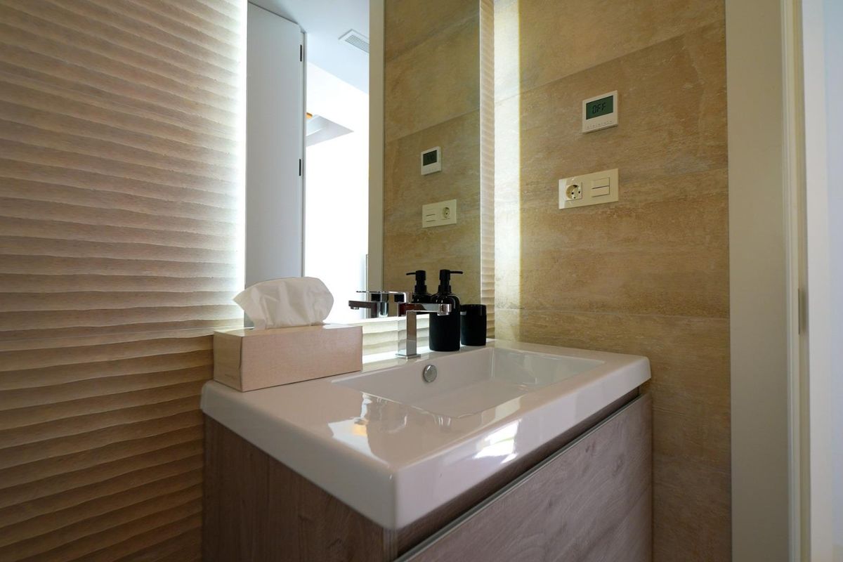 Elegante wastafel in de badkamer met moderne armaturen en natuurlijke materialen in de villa in Orihuela Costa.