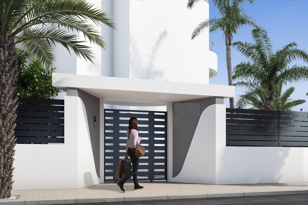 Moderne ingang van een penthouse in Guardamar del Segura, met goed onderhouden beplanting en een uitnodigende entree.