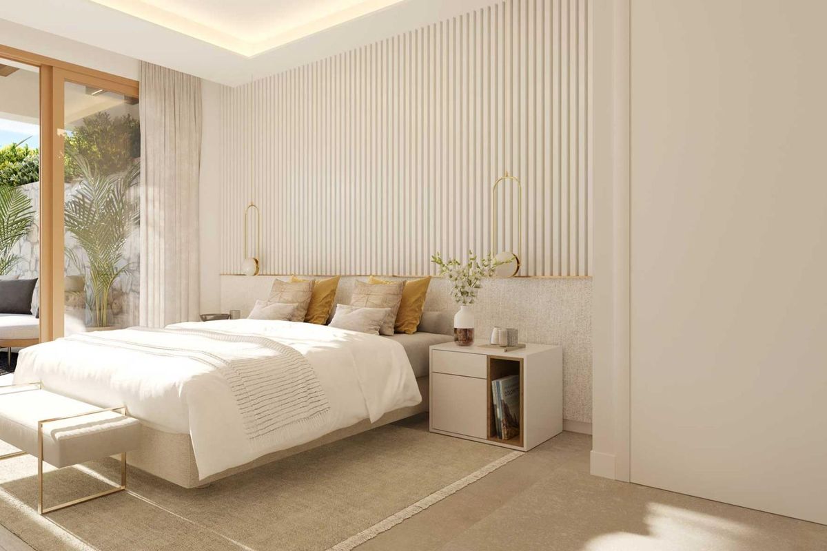 Elegant slaapkamer met luxe decor en toegang tot de tuin in een 2-slaapkamer appartement in Mijas, Costa del Sol.