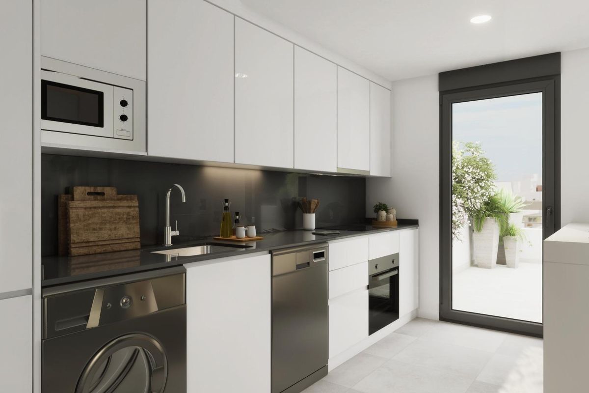 Contemporary keuken met witte kasten en overvloedig natuurlijk licht in het appartement in Estepona.