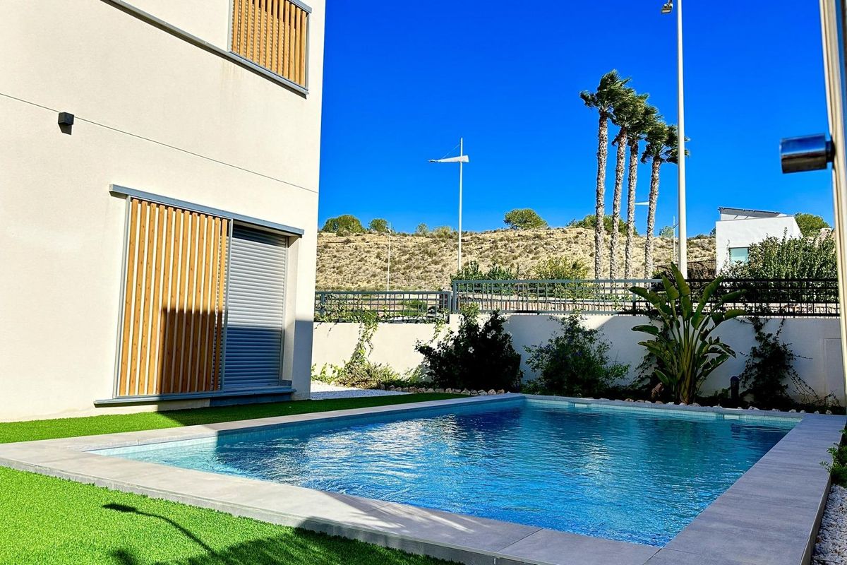 Zij-aanzicht van een modern villa met palmbomen en groenheid in Algorfa, Costa Blanca.