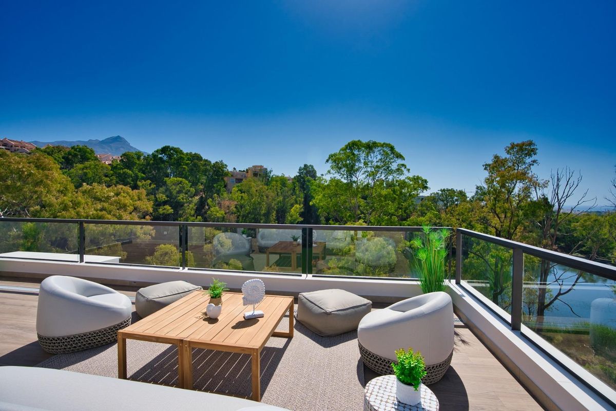Penthouse terras loungeplek omringd door groen en uitzicht in Marbella, Costa del Sol.