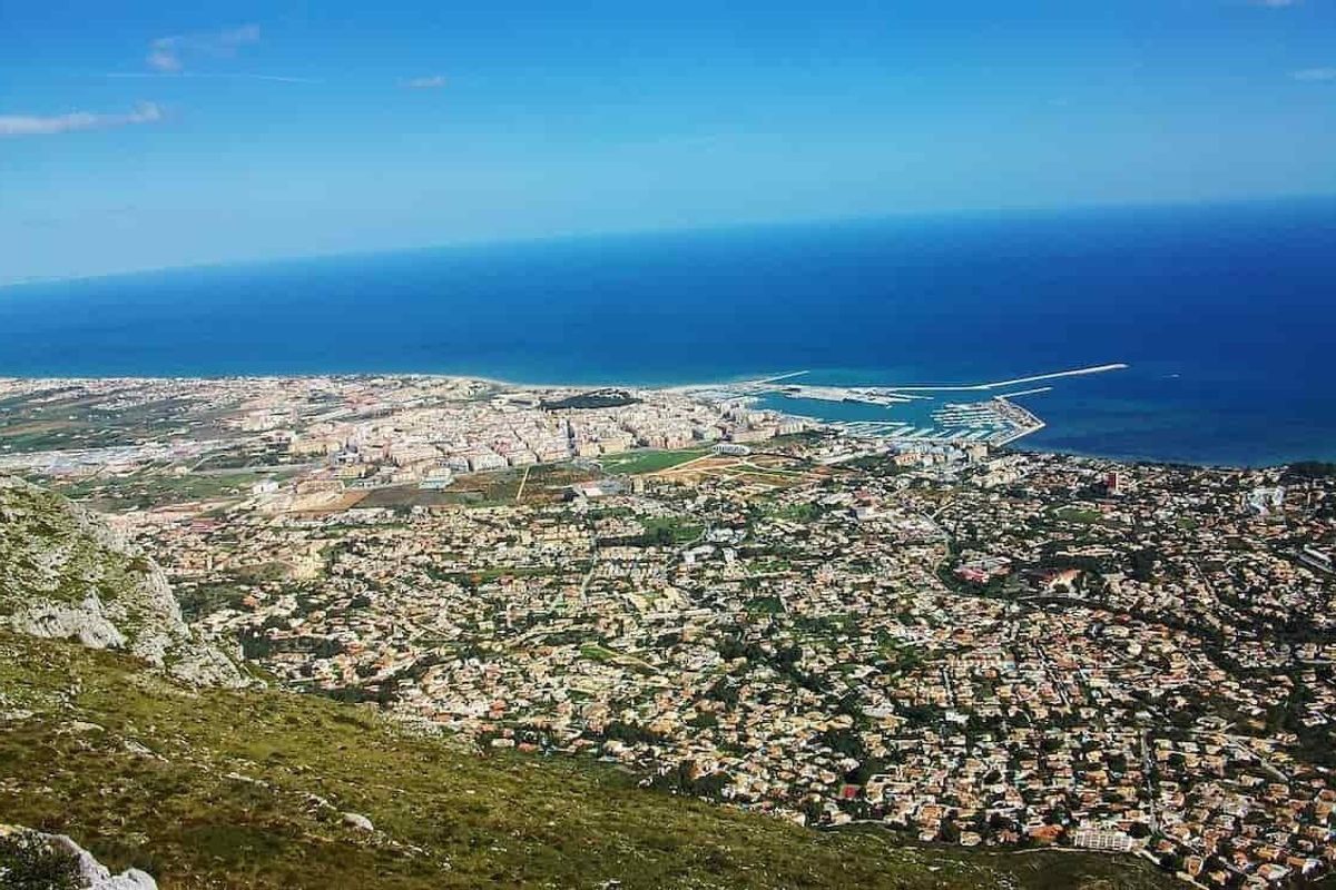 Panoramisch uitzicht op Denia met de kustlijn en omliggende gebieden vanuit de lucht.