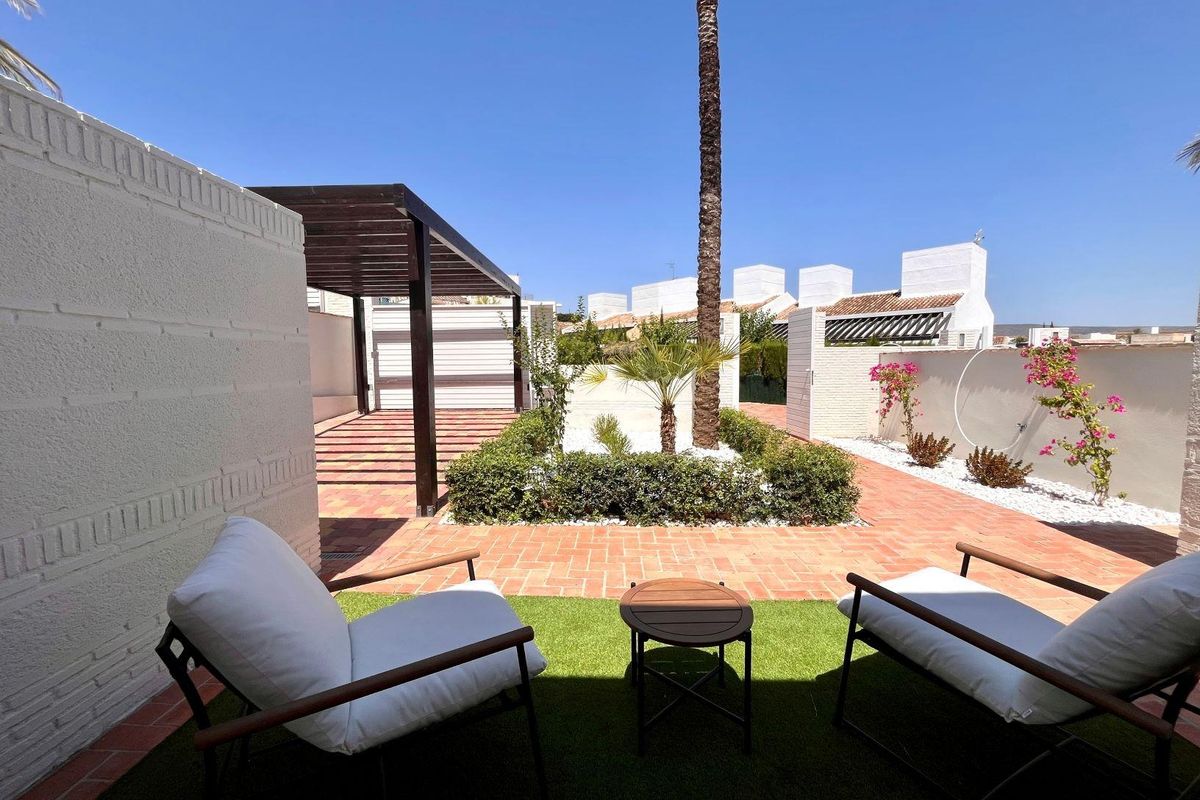 Charmante buitentuin met stoelen in een aangelegde tuin van een townhouse met 2 slaapkamers in Sucina.