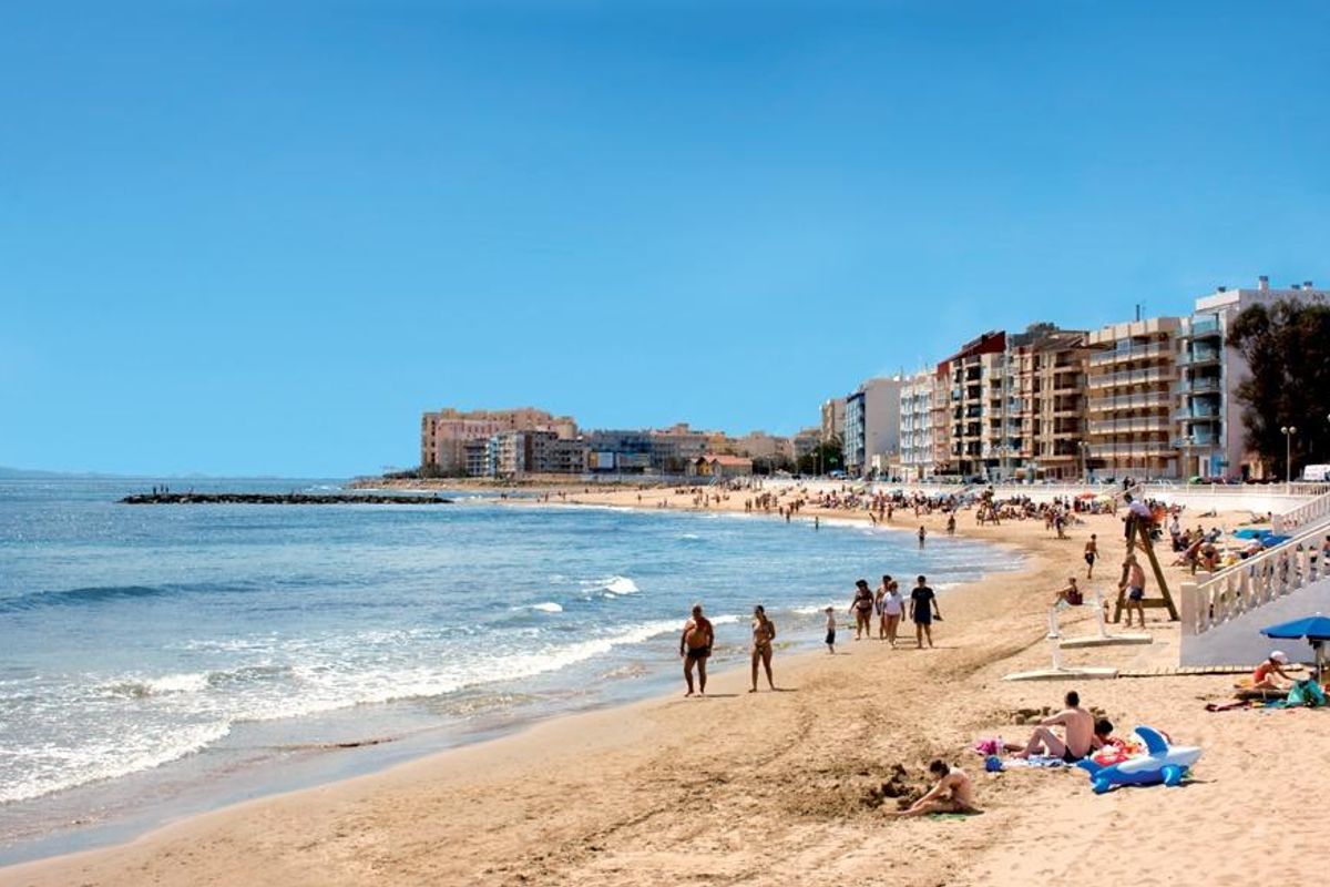 Strand in Torrevieja vol met zonnebaders en strandgangers die genieten van de warme Mediterrane zon.