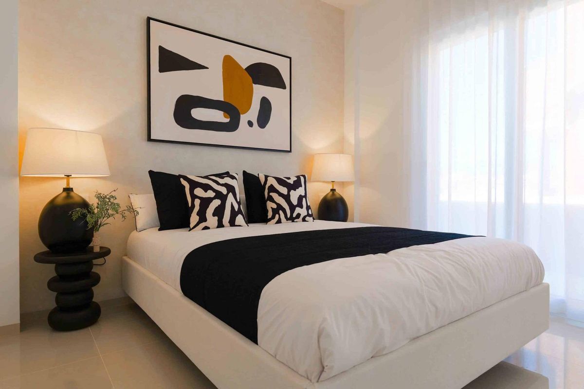 Chique slaapkamer met artistieke elementen en natuurlijk licht in een bungalow in Rojales.