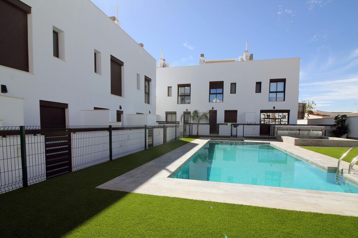 Buitenzicht op een moderne townhouse met zwembad, gelegen in Pilar de La Horadada, Costa Blanca Zuid.