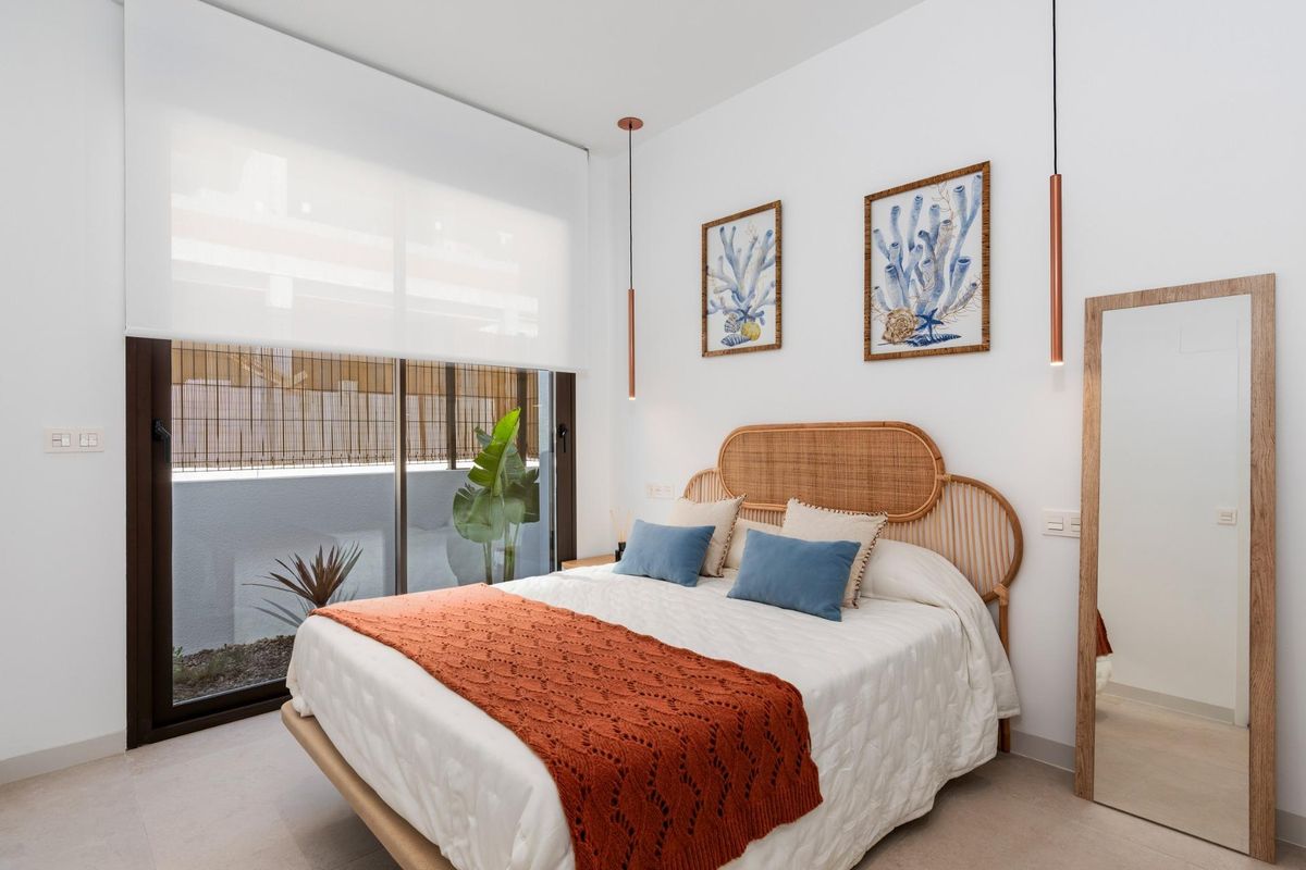 Gezellige slaapkamer met een tweepersoonsbed, planten en raamzicht in een 3-slaapkamer villa, Los Alcazares, Spanje.