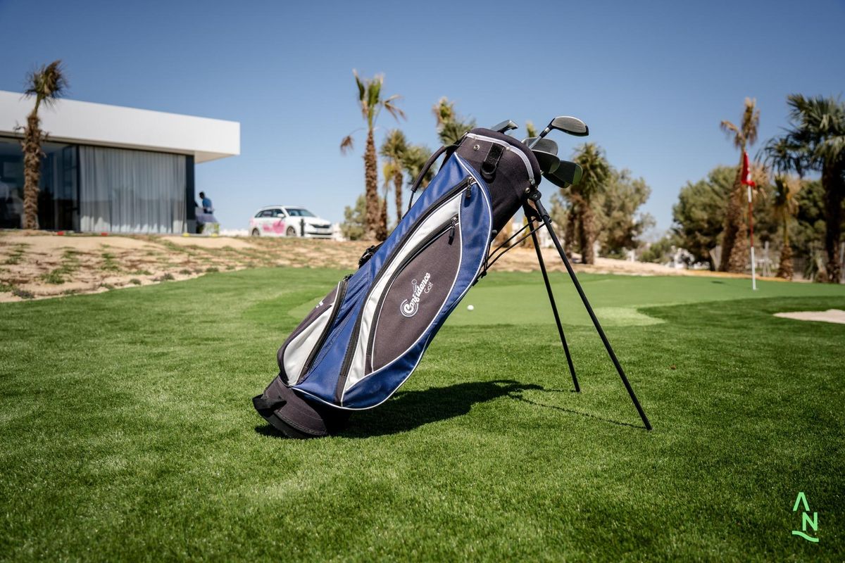 Golf tas rustend op het groene gras nabij een modern pand in Alhama De Murcia, Costa Calida.