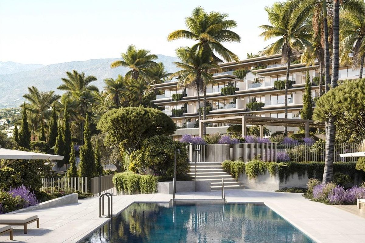 Rustige zwembad gebied omgeven door palmbomen in Mijas, perfect om te ontspannen in een 3-slaapkamer appartement.