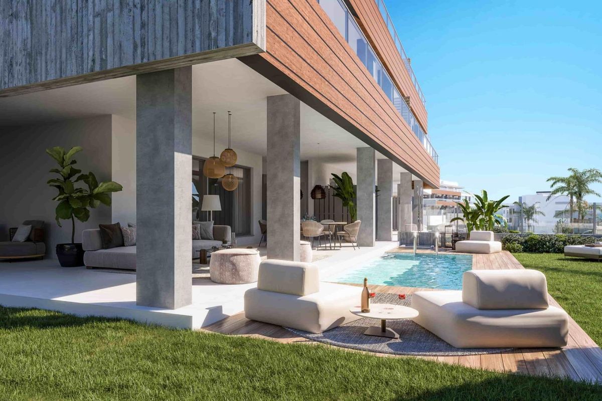 Stijlvolle buitenzitruimte bij het zwembad, omgeven door groen, in een luxe penthouse in Marbella.