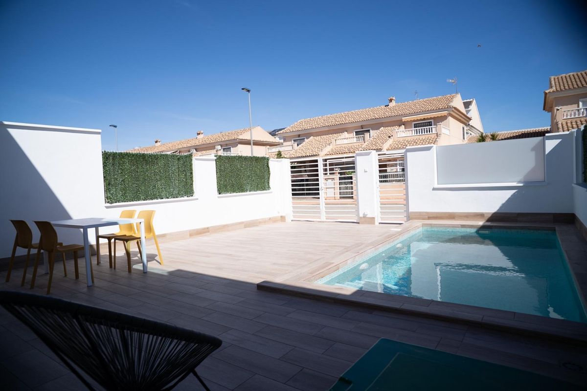 Exterior view of a townhouse terrace with a private pool in San Javier, Costa Calida, Spain. Seating is visible.