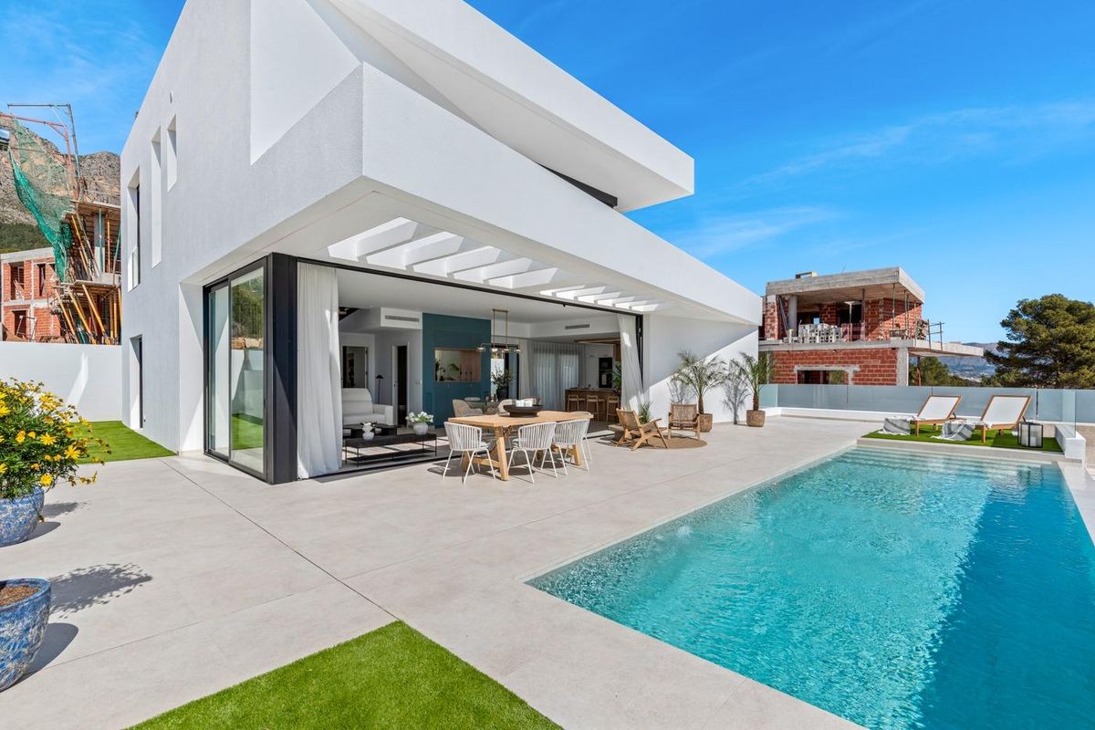 Alfresco eetgedeelte bij het zwembad van een villa in Polop, met moderne architectuur.