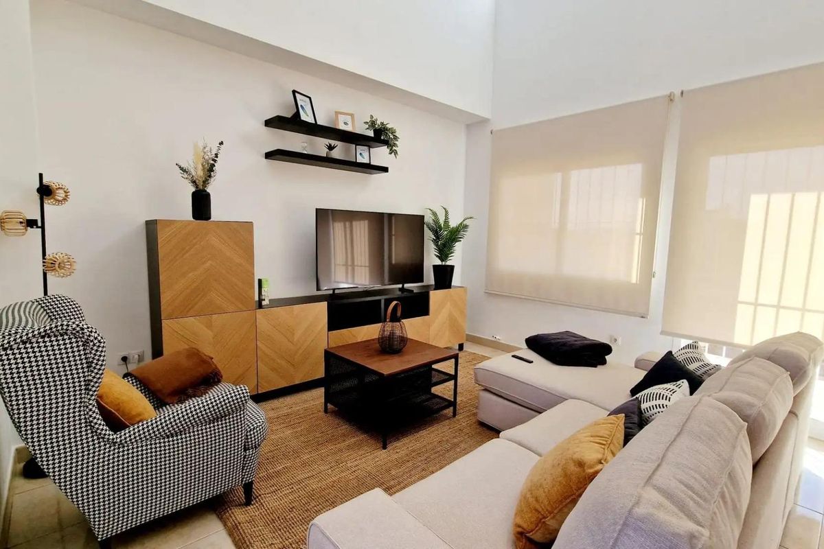 Uitzicht op de woonkamer dat een stijlvolle bank en modern tv-meubel in de villa in Lorca benadrukt.