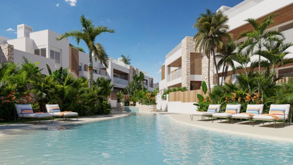 Tropisch zwembad met weelderige groenvoorzieningen en moderne appartementen in San Juan de los Terreros.