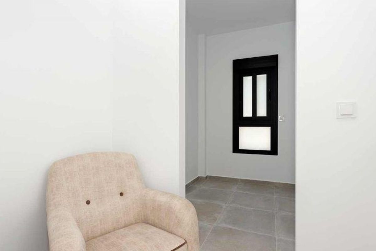 Stijlvolle hoek met een comfortabele fauteuil, gelegen in de gang van de bungalow in Daya Nueva, biedt ontspanning.