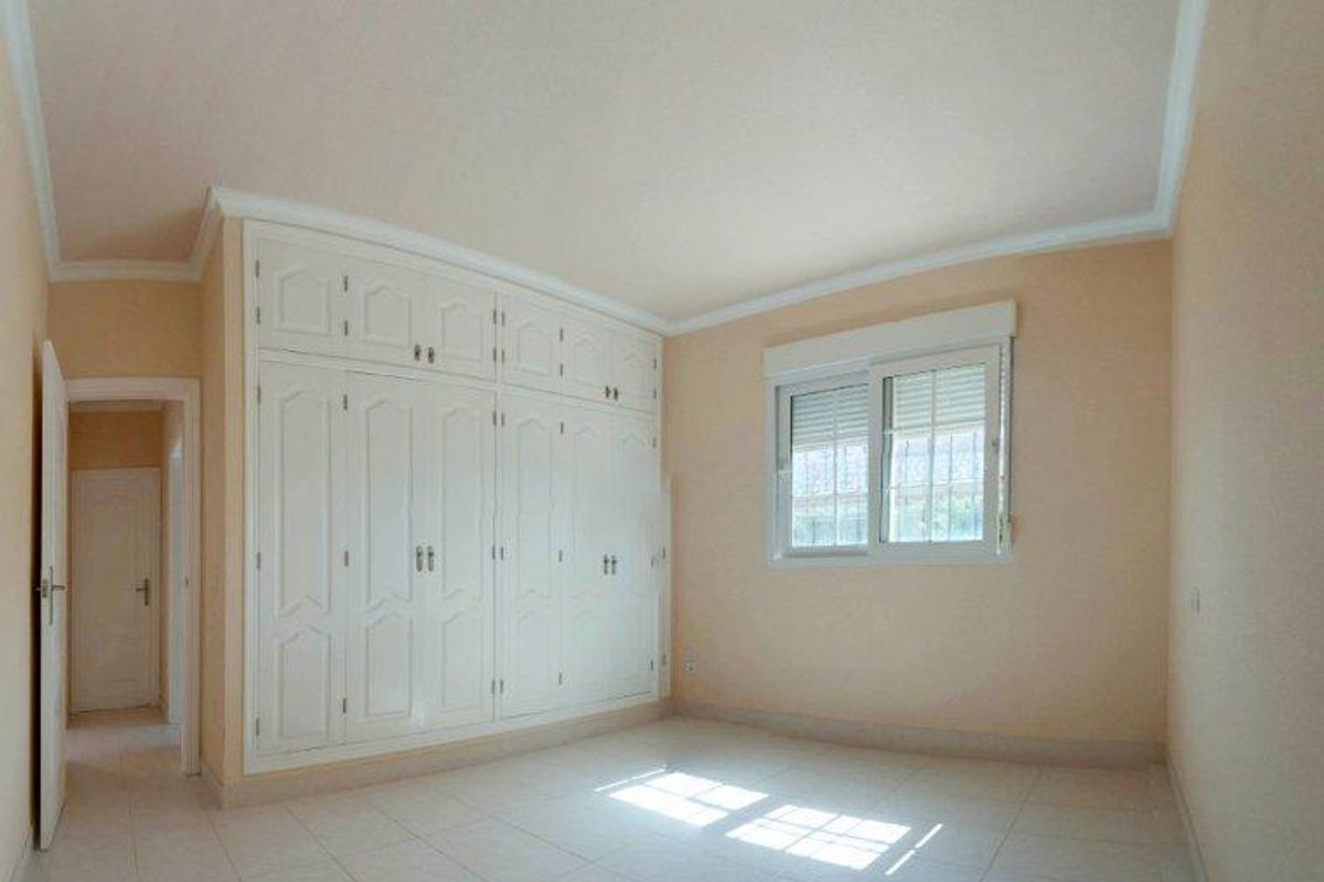 Heldere en luchtige slaapkamer met inbouwkasten en natuurlijk zonlicht.