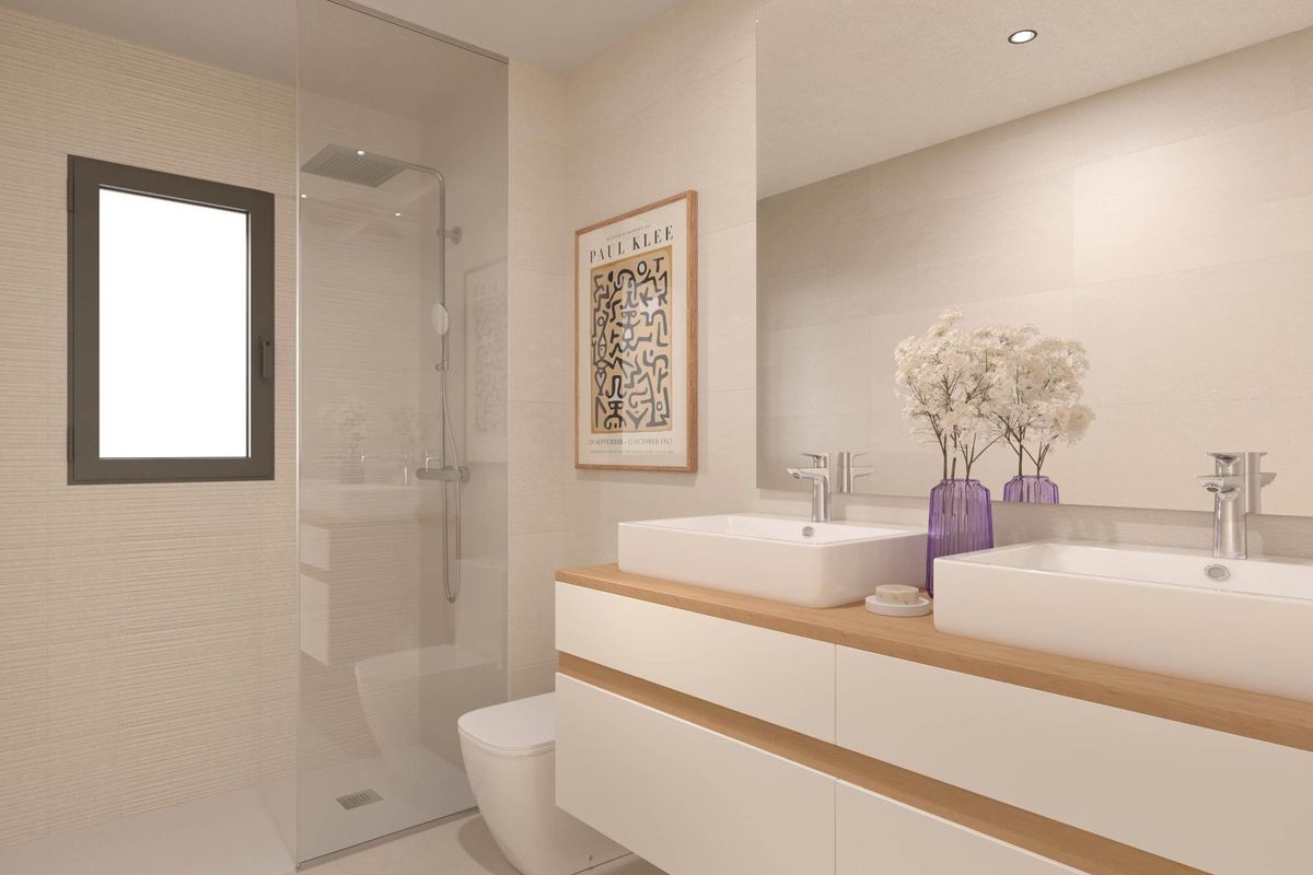 Stijlvolle badkamer met moderne armaturen en dubbele wastafels in een appartement op de begane grond in Torremolinos.