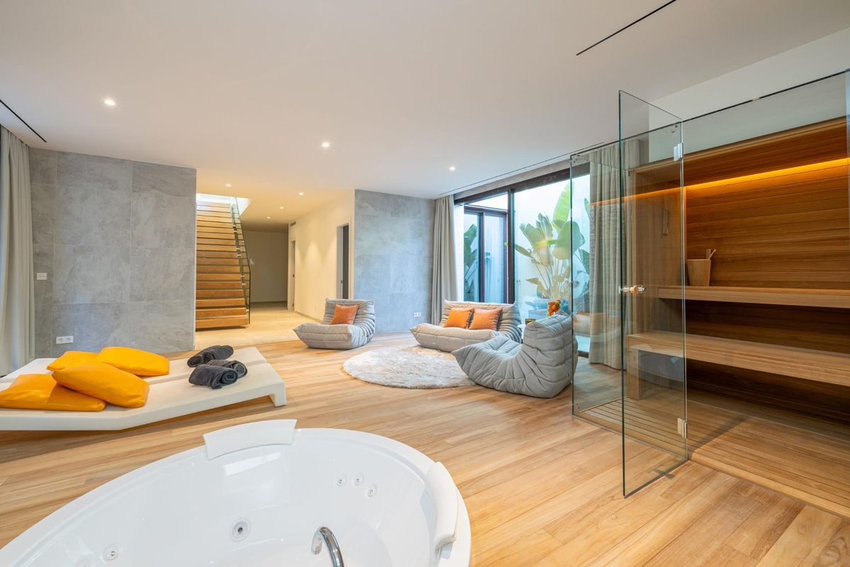 Breedbeeld van spa ruimte in een tussenwoning in fuengirola, costa del sol, met sauna, bad, ligbedden en trap naar andere verdiepingen.