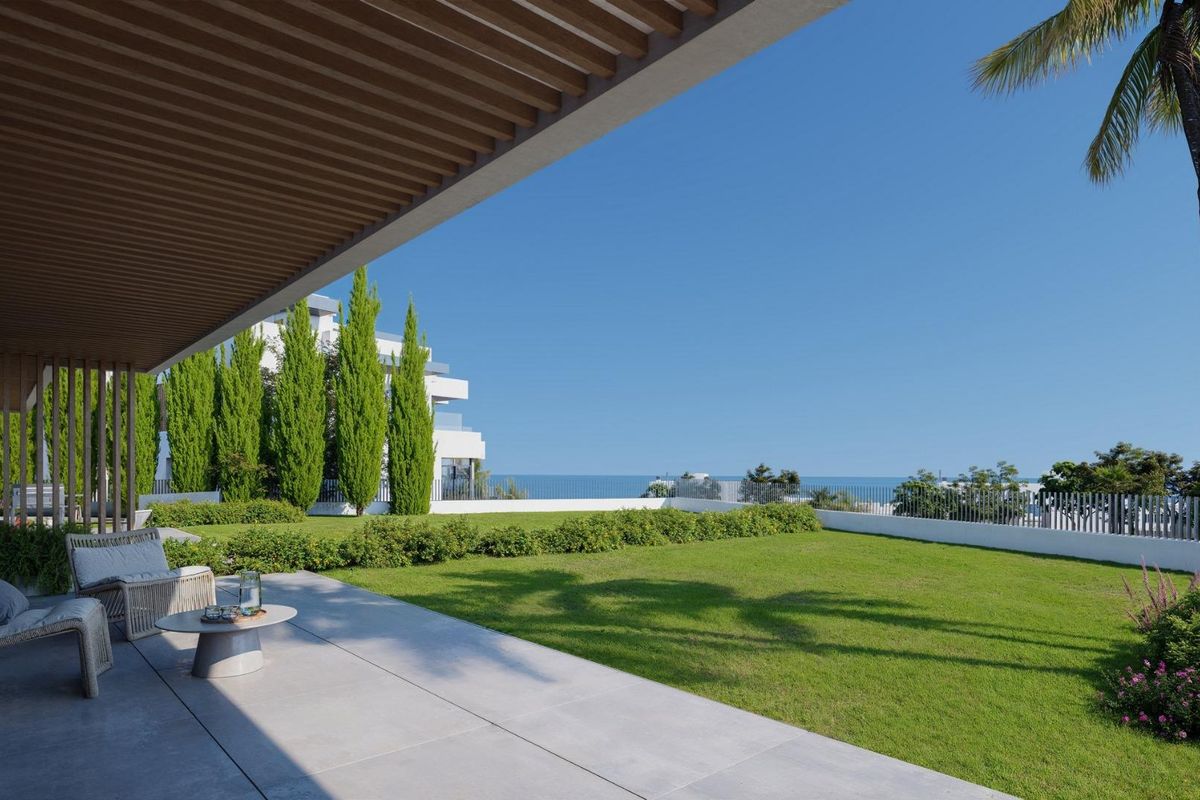 Ruim terras met uitzicht op zee vanuit een appartement op de begane grond in Mijas, gelegen in een groene tuin.