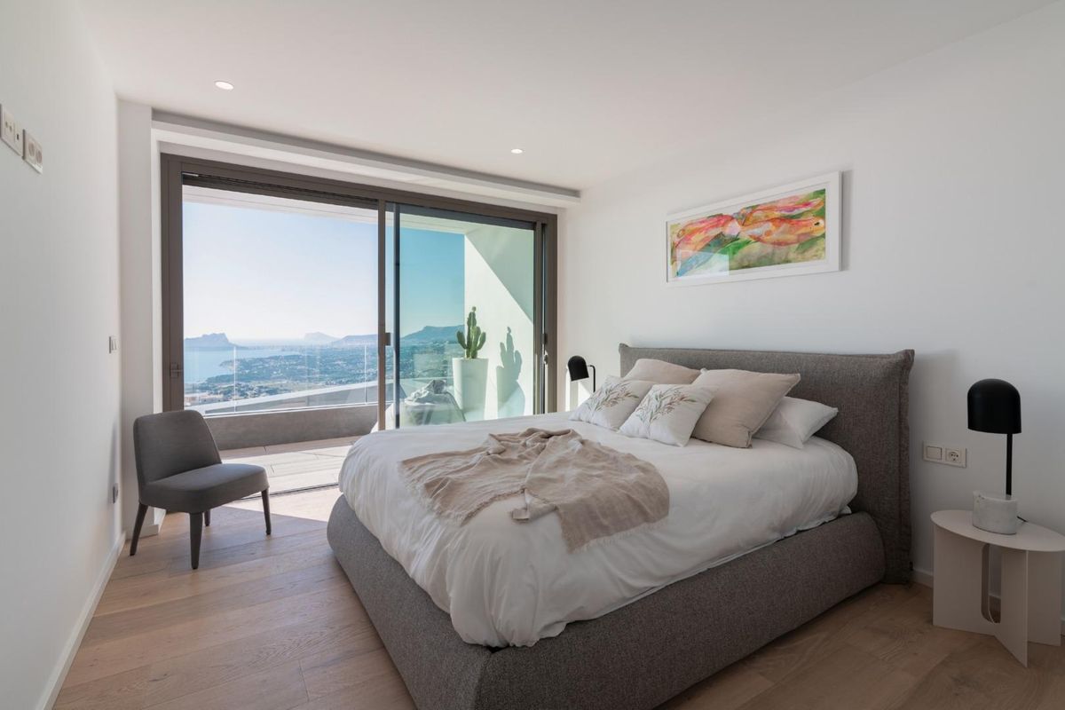 Modern bedroom with coastal views in a Benitachell villa, showcasing stylish decor and comfort.