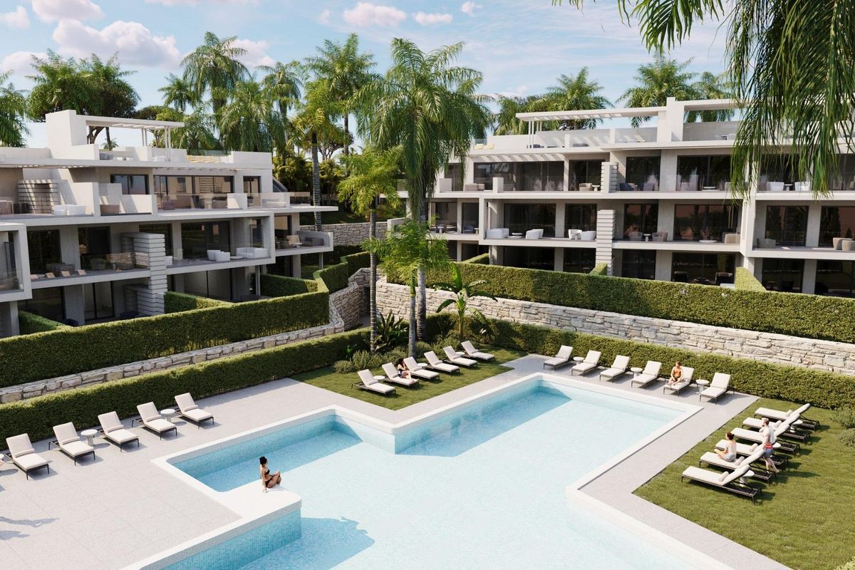 Zwemgebied van het penthousecomplex in Estepona, Costa del Sol, met luxe loungemogelijkheden te midden van tuinen.