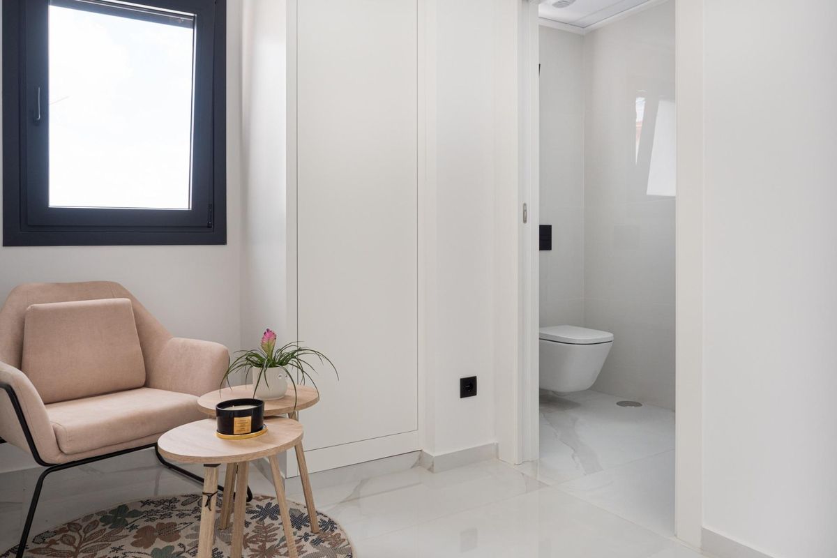 Gezellige hoek met een stoel en tafeltje in een goed verlichte ruimte van het interieur van een villa in San Pedro del Pinatar.