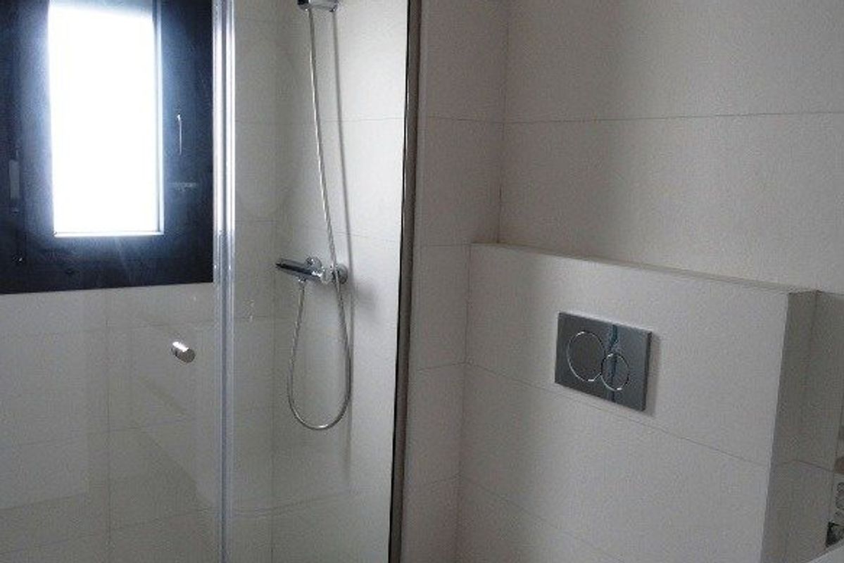 Een ander uitzicht op de moderne badkamer met glazen douche in een townhouse gelegen in Pilar de La Horadada.