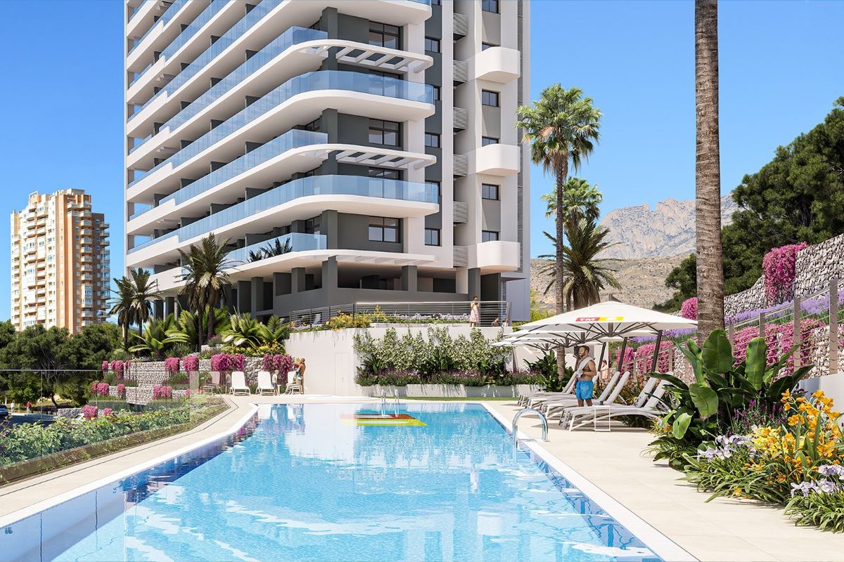 Uitnodigend zwembad omgeven door tropische tuinen in een luxe appartementcomplex in Benidorm.