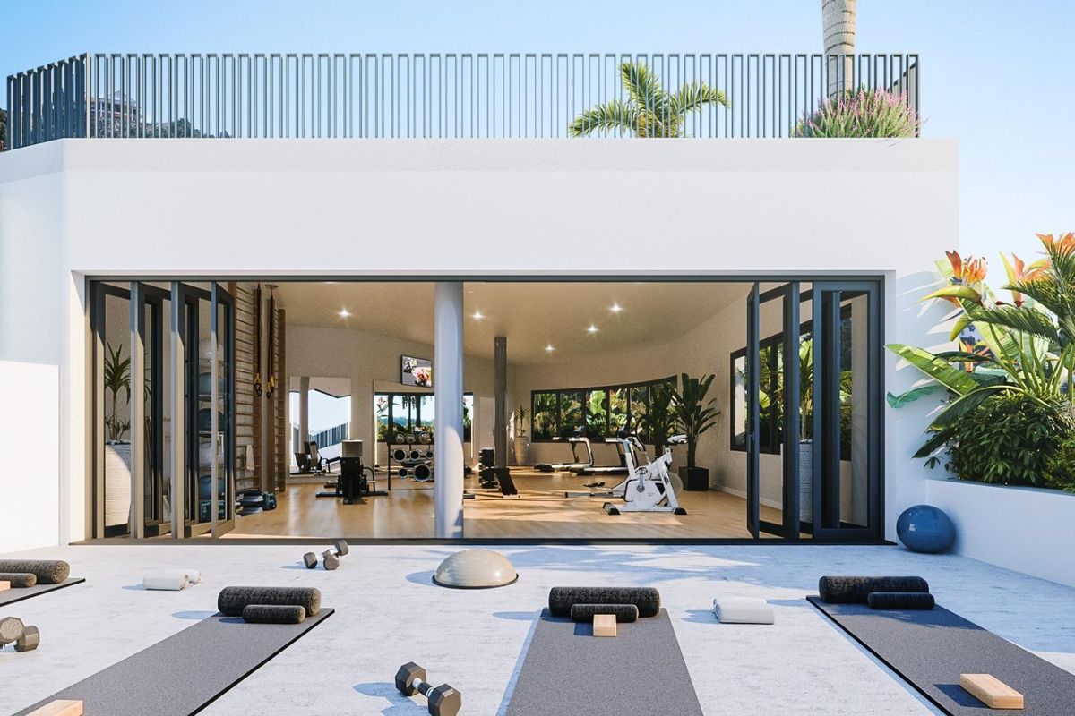 Buitenfitnessruimte met fitnessapparatuur en yogamatten, gelegen in een penthousecomplex in Marbella.