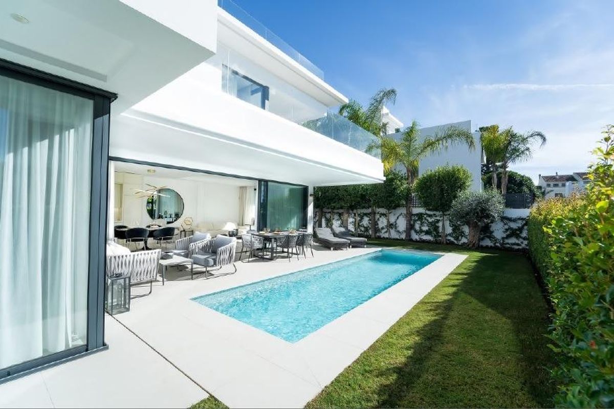 Uitzicht op het privézwembad van de villa en de buitenzitjes, met moderne architectuur in Marbella.