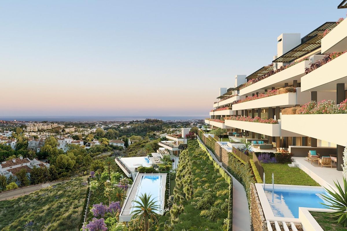 Buitenzicht op een luxe appartementencomplex omringd door tuinen in Benahavís, Costa del Sol.