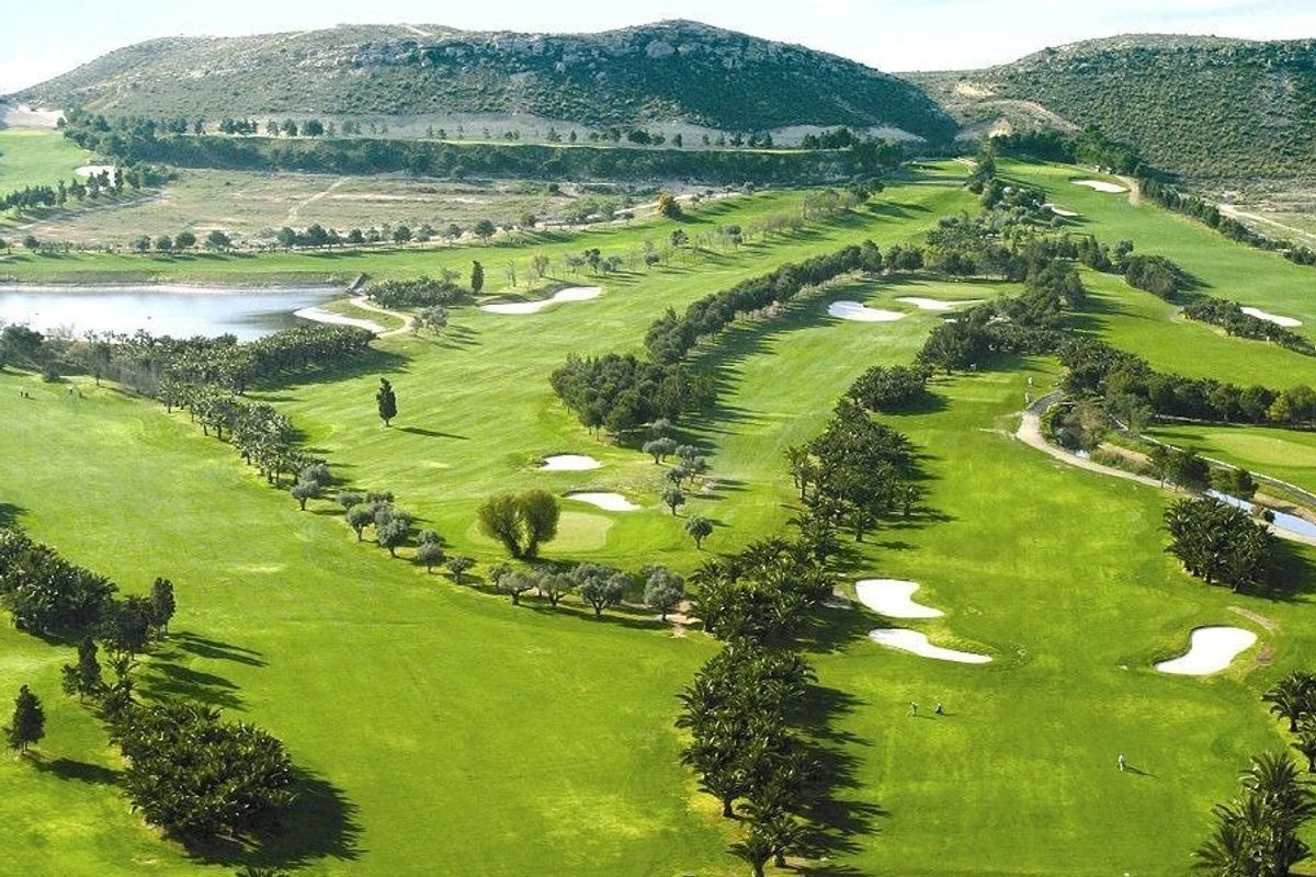 Aerial view of a lush golf course near Baños y Mendigo, featuring well-maintained greens.