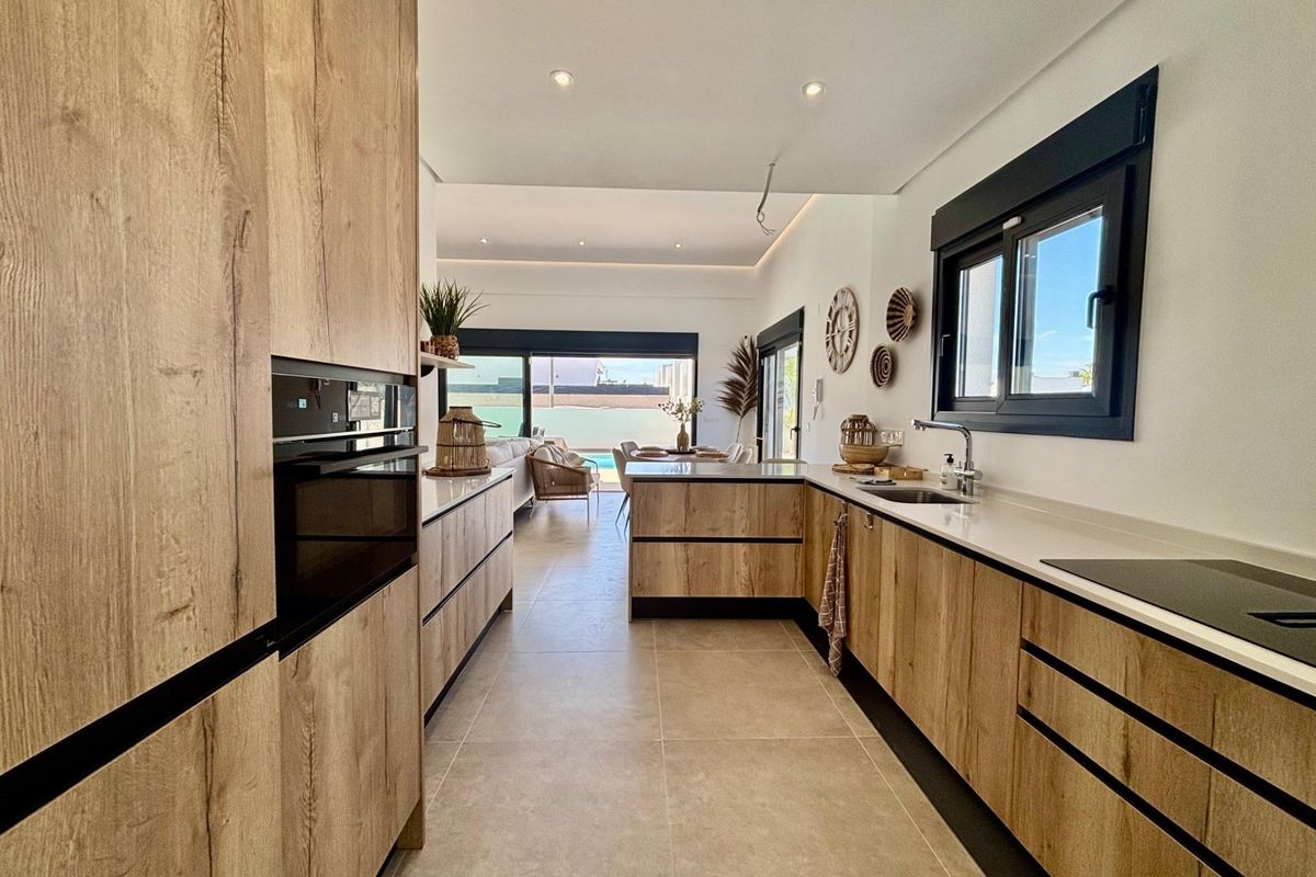 Hedendaagse keukenindeling in een villa in Rojales, met slanke kasten en open ontwerp voor gemakkelijk wonen.