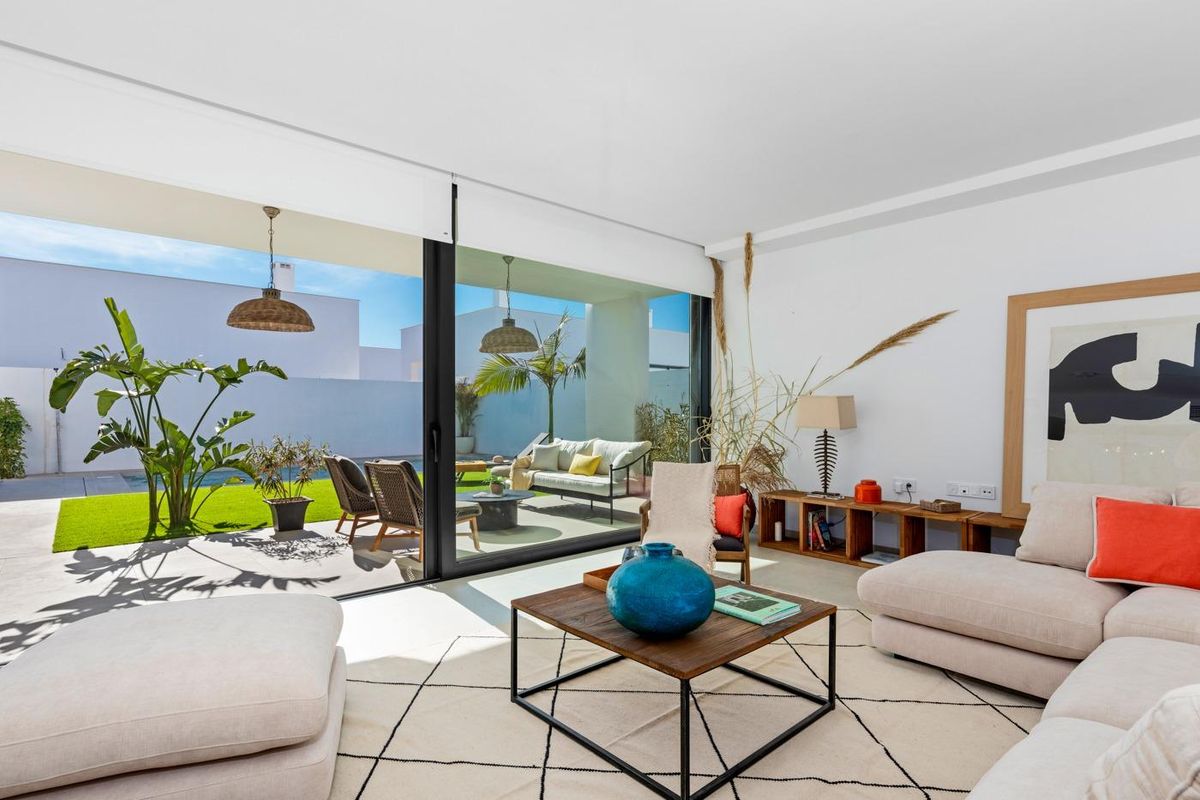 Zonnige woonkamer met grote ramen die uitzicht bieden op de tuin in een villa in Cartagena, Costa Calida.