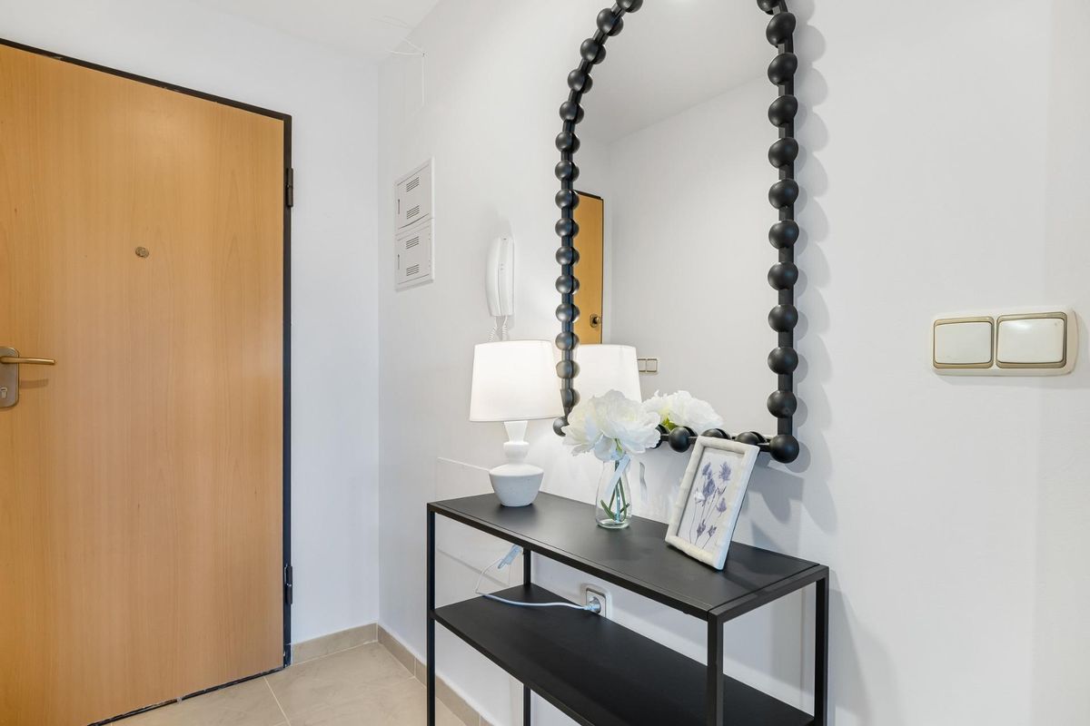 Nabijopname van de entree met een spiegel en decoratieve elementen in de penthouse.